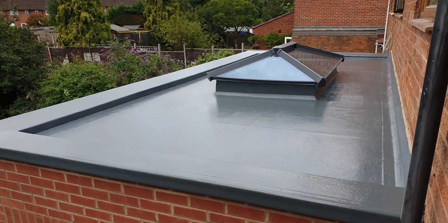 Completed grey GRP flat roof with glass lantern skylight